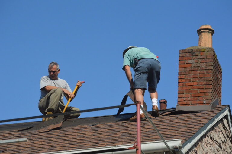 two roofers repairing the damaged roof | Champion Roofers