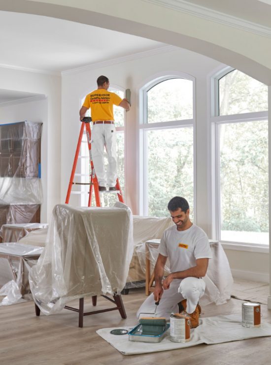 two workers in a house doing interior restoration