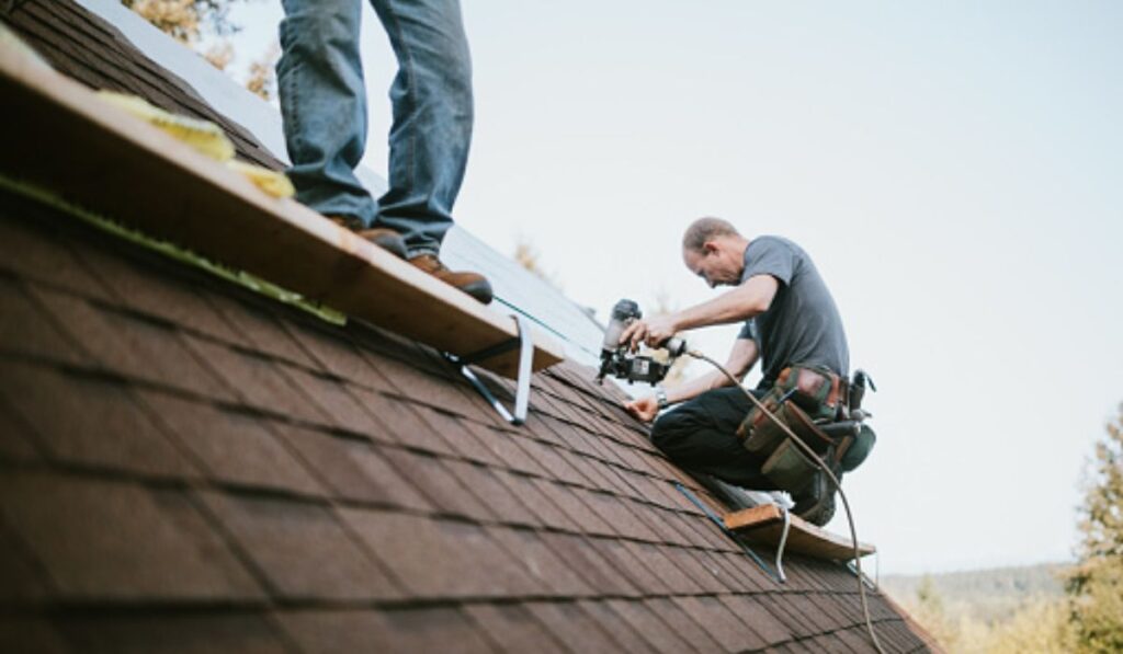 two roofers repairing the roof
